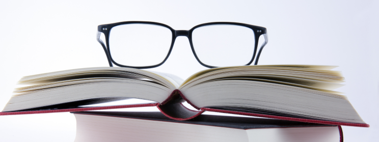 glasses sitting on a pile of books